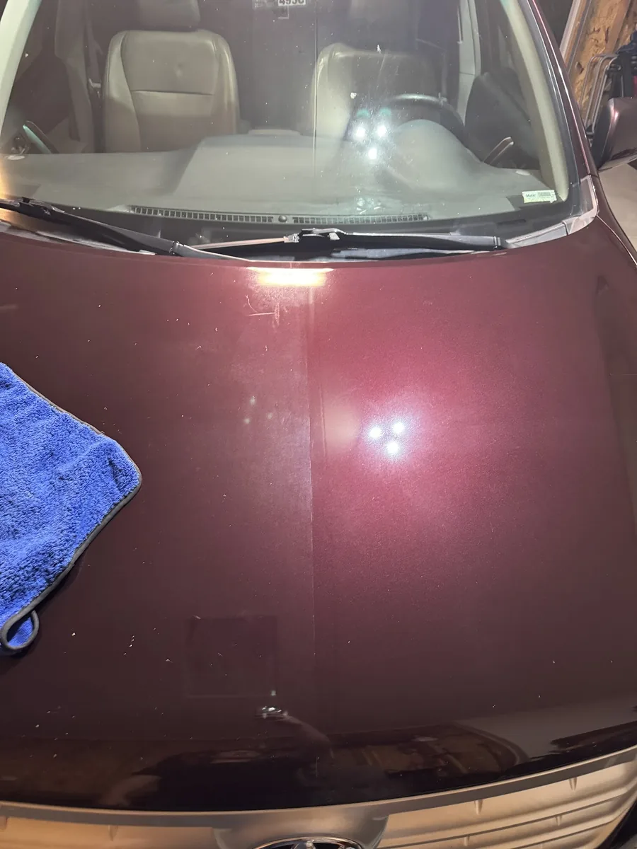 Maroon hood mid-polish showing paint being restored